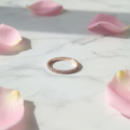 Anello Eternity Pavé Oro Rosa su marmo con petali rosa