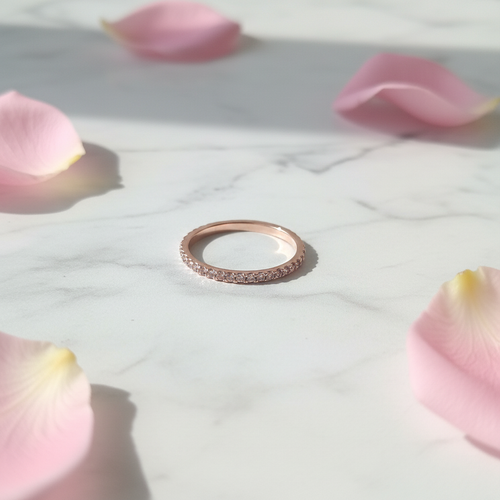 Anello Eternity Pavé Oro Rosa su marmo con petali rosa