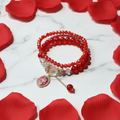 Bracciale Doppio Cristalli Rossi flat lay su marmo con petali