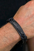 Bracciale Uomo Cuoio Nero Placca Piuma Incisa — dettaglio polso macro